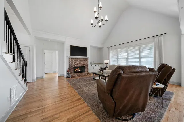 a kitchen with stainless steel appliances granite countertop a stove a sink dishwasher a refrigerator and white cabinets with wooden floor