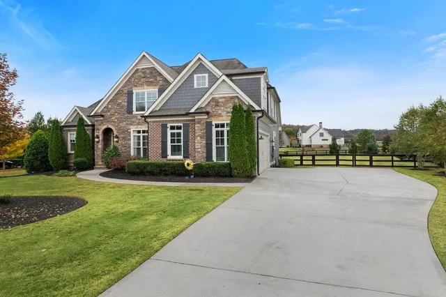 a view of a big house with a big yard and potted plants