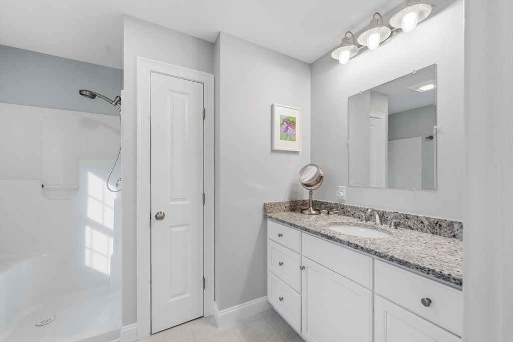 44 Bacon Street Pepperell, MA 01463 - Photo 22 of 42 a bathroom with a granite countertop sink and a mirror