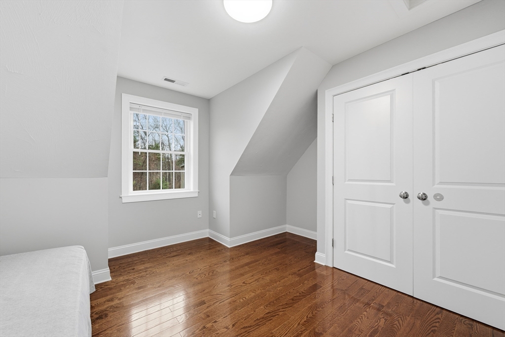 44 Bacon Street Pepperell, MA 01463 - Photo 27 of 42 a view of an empty room with wooden floor and a window