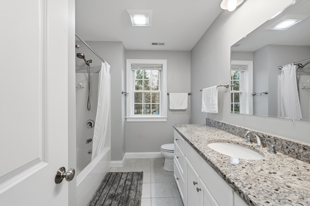 44 Bacon Street Pepperell, MA 01463 - Photo 28 of 42 a bathroom with a granite countertop sink a mirror a toilet and a shower