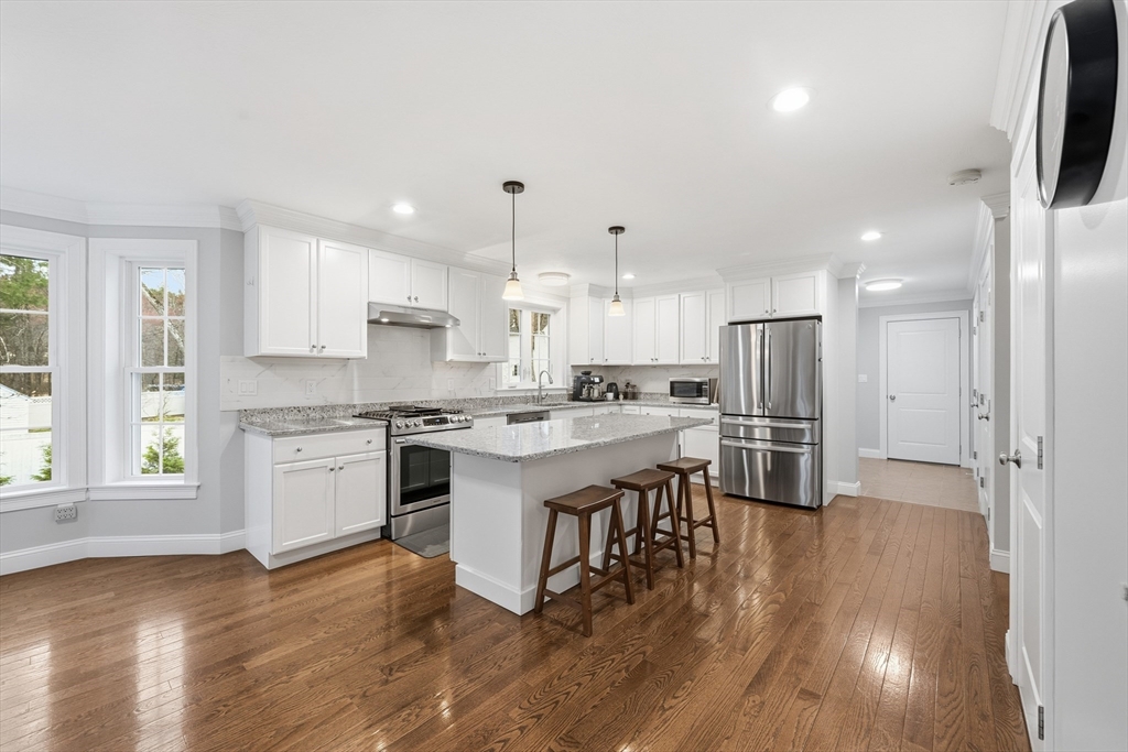 44 Bacon Street Pepperell, MA 01463 - Photo 7 of 42 a kitchen with a refrigerator and white cabinets