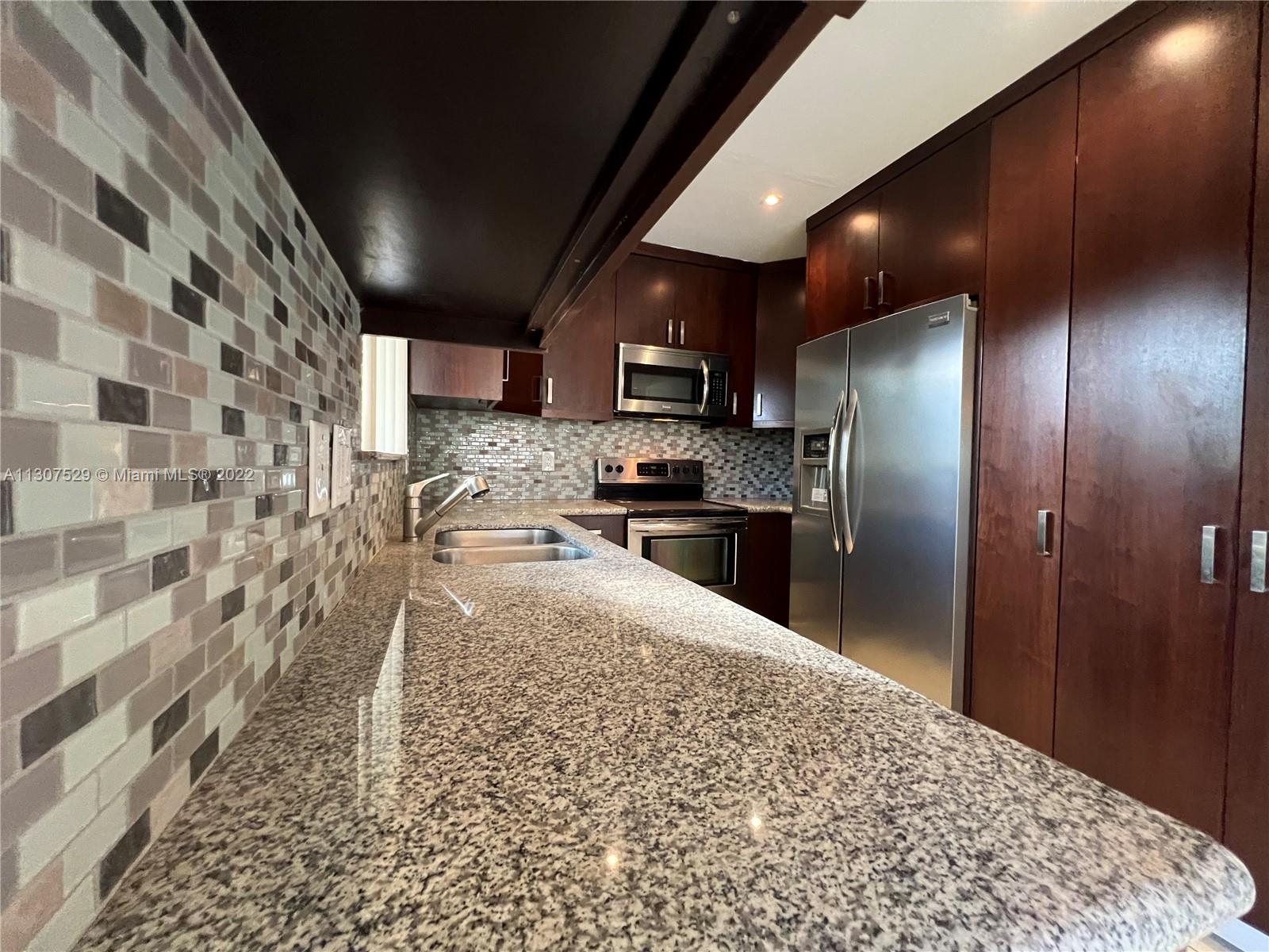 159 Northwest 70th Street, Unit 512 Boca Raton, FL 33487 - Photo 11 of 43 a kitchen with granite countertop stainless steel appliances a sink and a counter top space