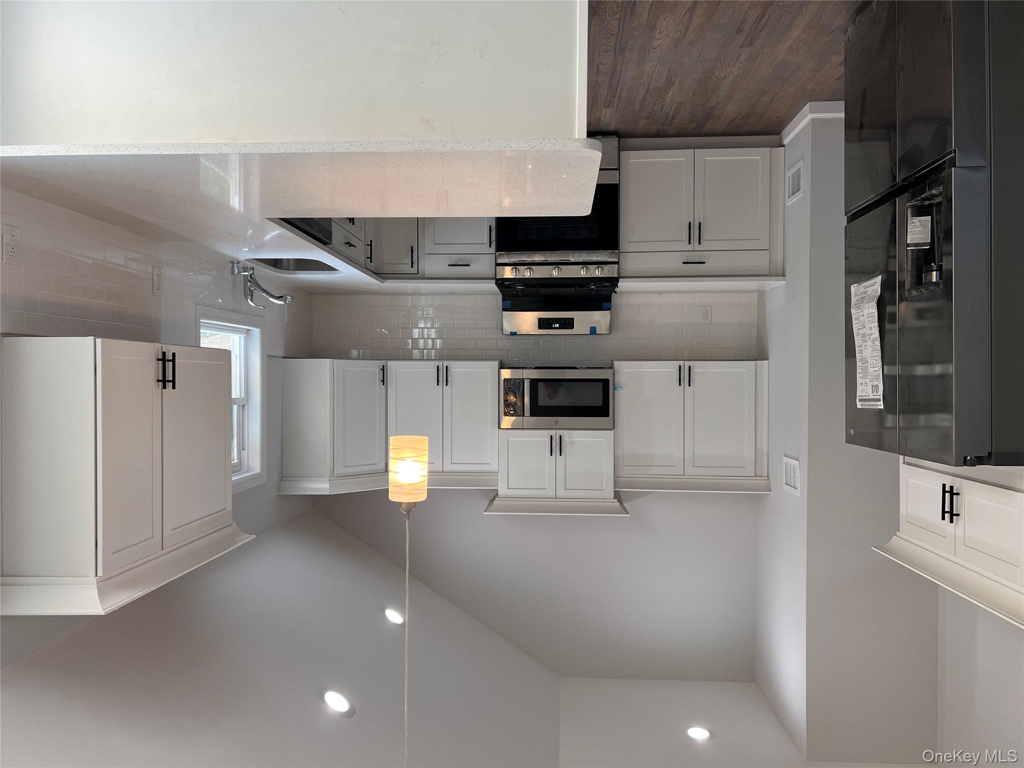 56 Aspen Road Mastic Beach, NY 11951 - Photo 8 of 13 a kitchen that has a lot of cabinets a sink and appliances in it