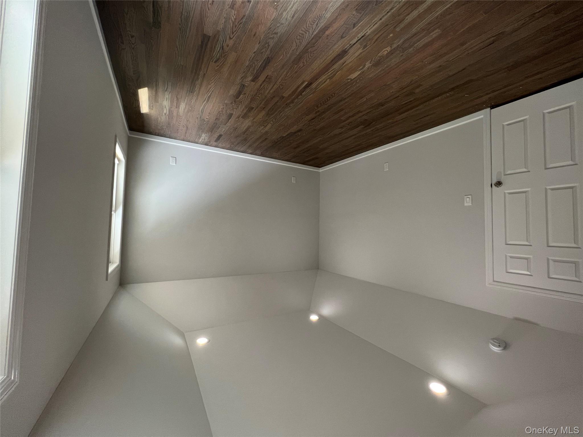 56 Aspen Road Mastic Beach, NY 11951 - Photo 10 of 13 an empty room with wooden floor and windows