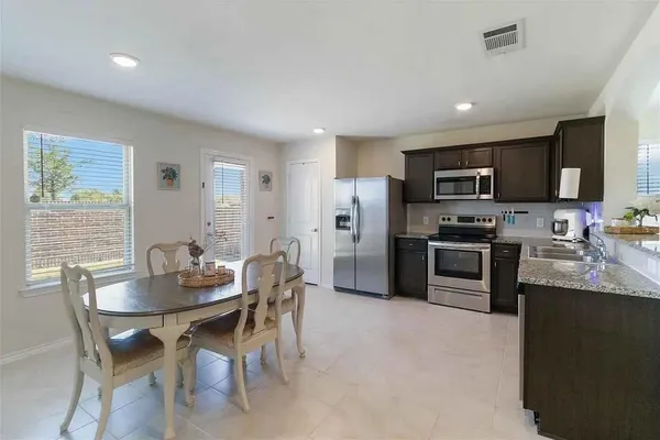 a kitchen with refrigerator cabinets dining table and chairs