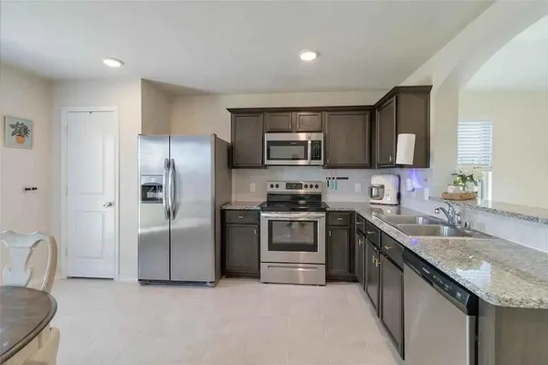 a kitchen with stainless steel appliances granite countertop a refrigerator sink and stove