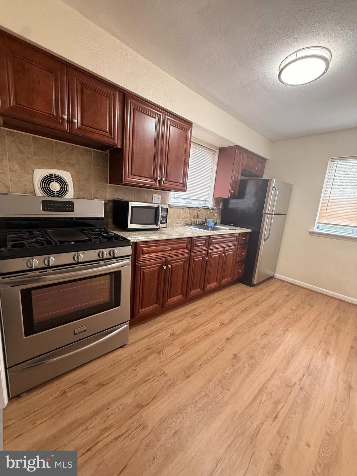 216 Boro Road, Unit A Secane, PA 19018 - Photo 11 of 26 a kitchen with stainless steel appliances granite countertop a stove a sink and a refrigerator
