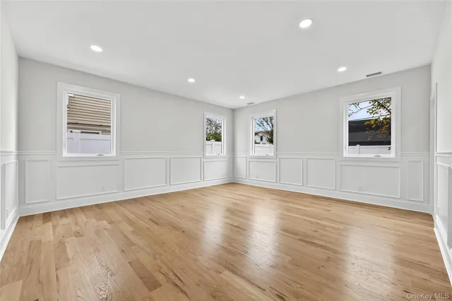 a view of empty room with wooden floor and window