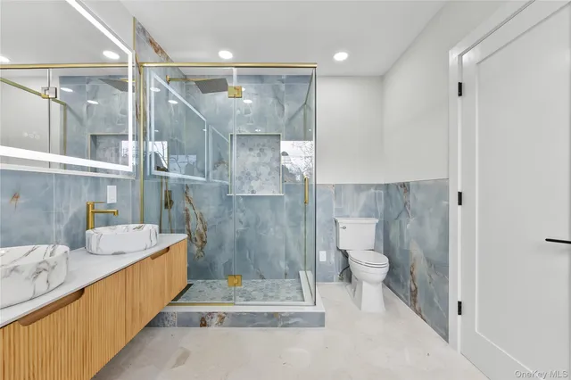 a bathroom with a tub sink mirror and toilet