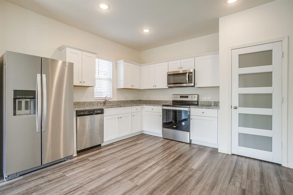 1405 Gentle Crk Lane Fort Worth, TX 76052 - Photo 22 of 40 a kitchen with granite countertop a refrigerator stove top oven and sink