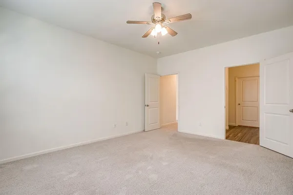 an empty room with a ceiling fan and a window
