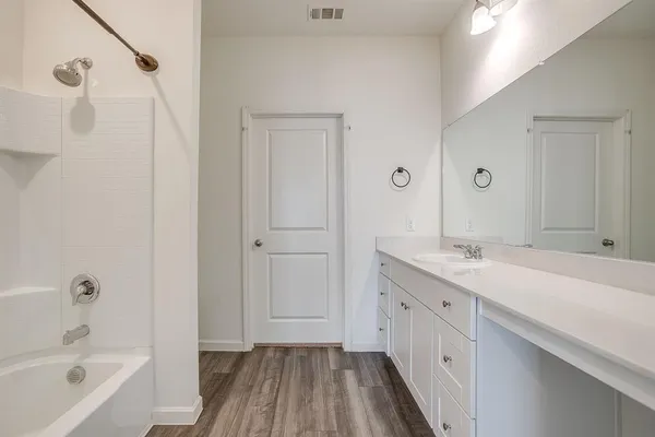 a bathroom with a tub sink and mirror