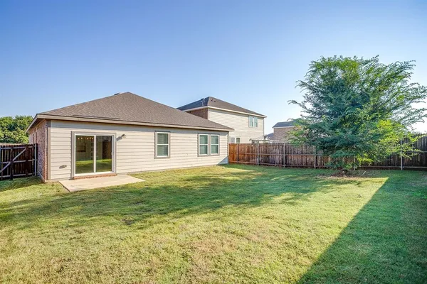 a backyard of a house with table and chairs