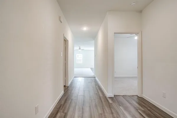 a view of a hallway with wooden floor