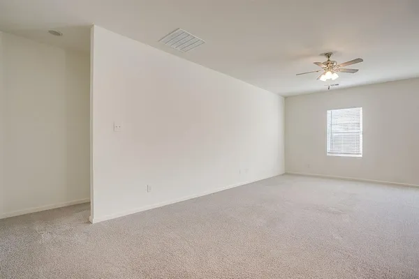 an empty room with windows and fan