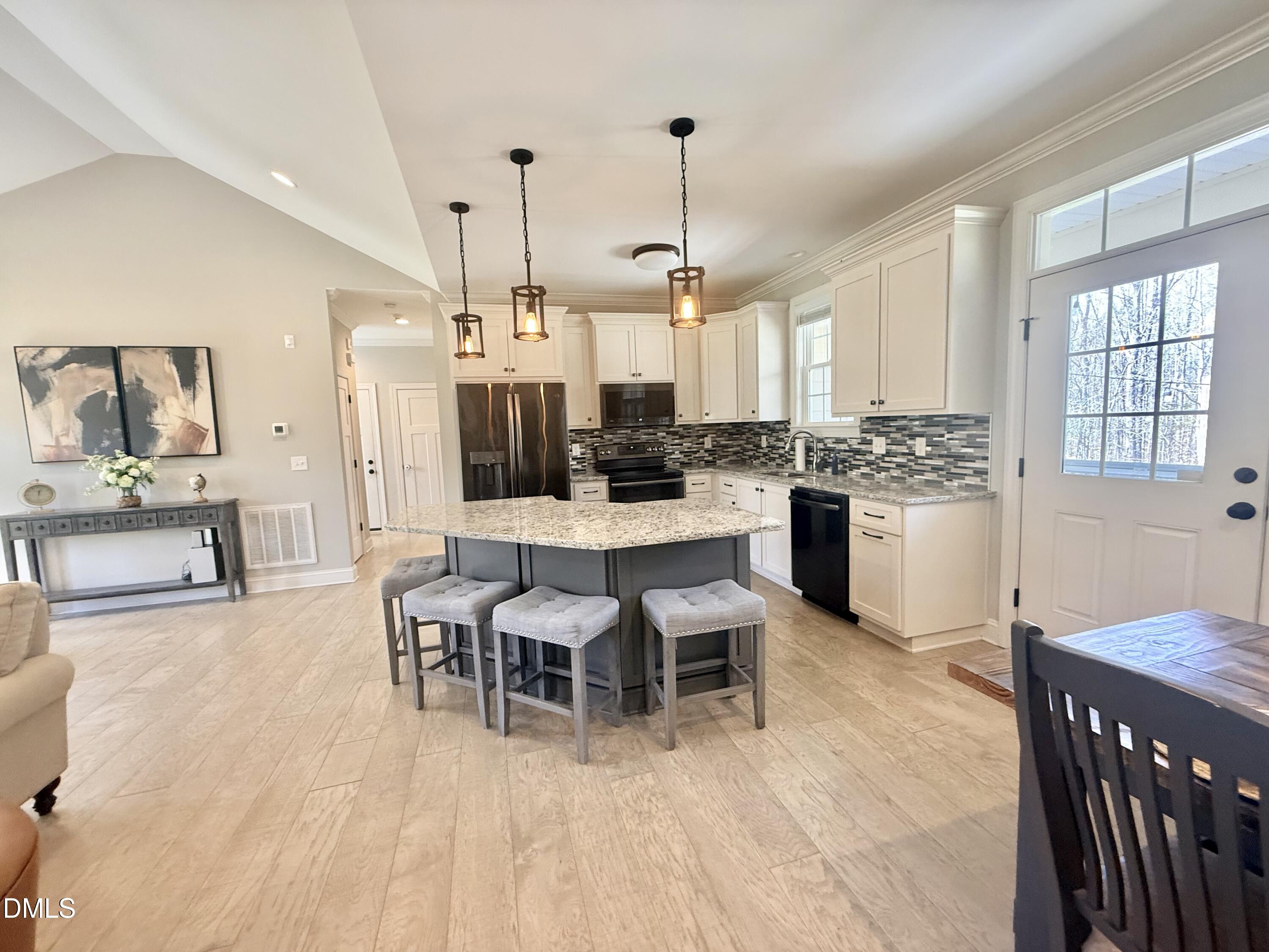128 Bessie Lane Roxboro, NC 27574 - Photo 14 of 55 a dining room with stainless steel appliances kitchen island granite countertop a table chairs and a view of living room