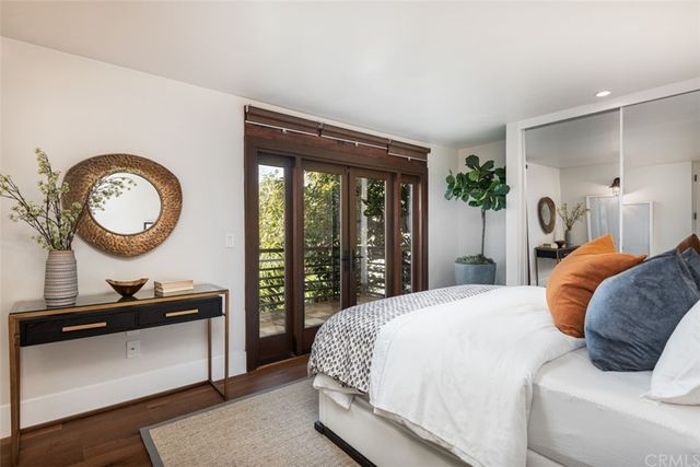 a bedroom with a bed a mirror and a window