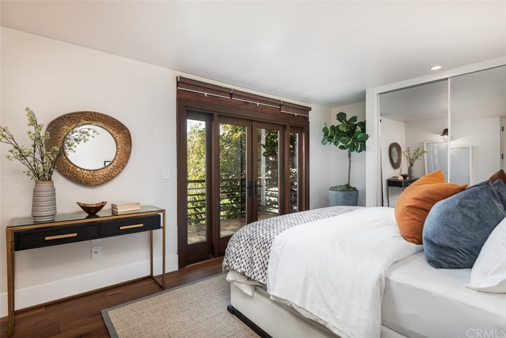 247 Emerald Bay Laguna Beach, CA 92651 - Photo 27 of 47 a bedroom with a bed a mirror and a window