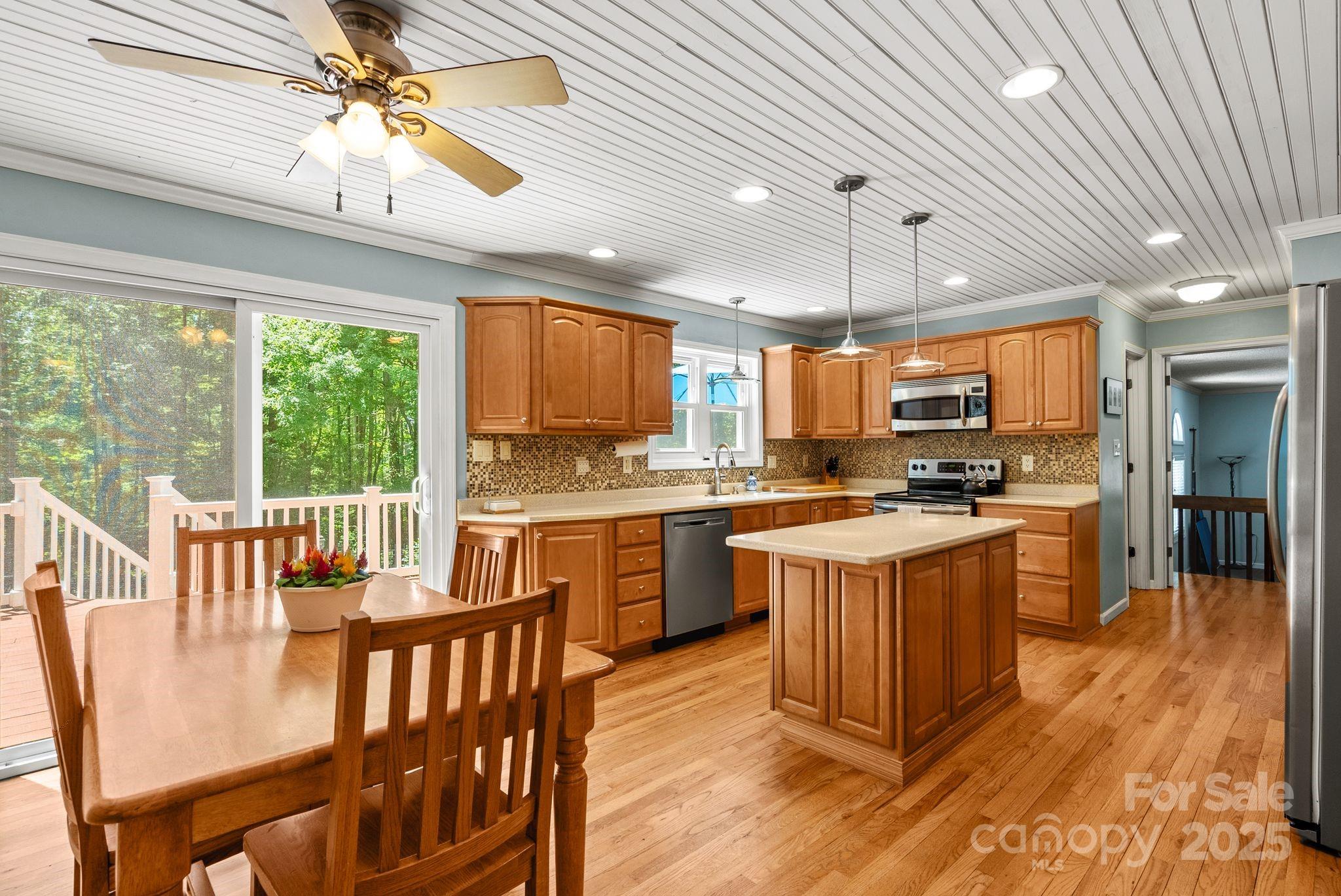 41 Glen Cove Road Arden, NC 28704 - Photo 11 of 39 a kitchen with stainless steel appliances granite countertop a stove top oven a sink dishwasher a dining table and chairs with wooden floor