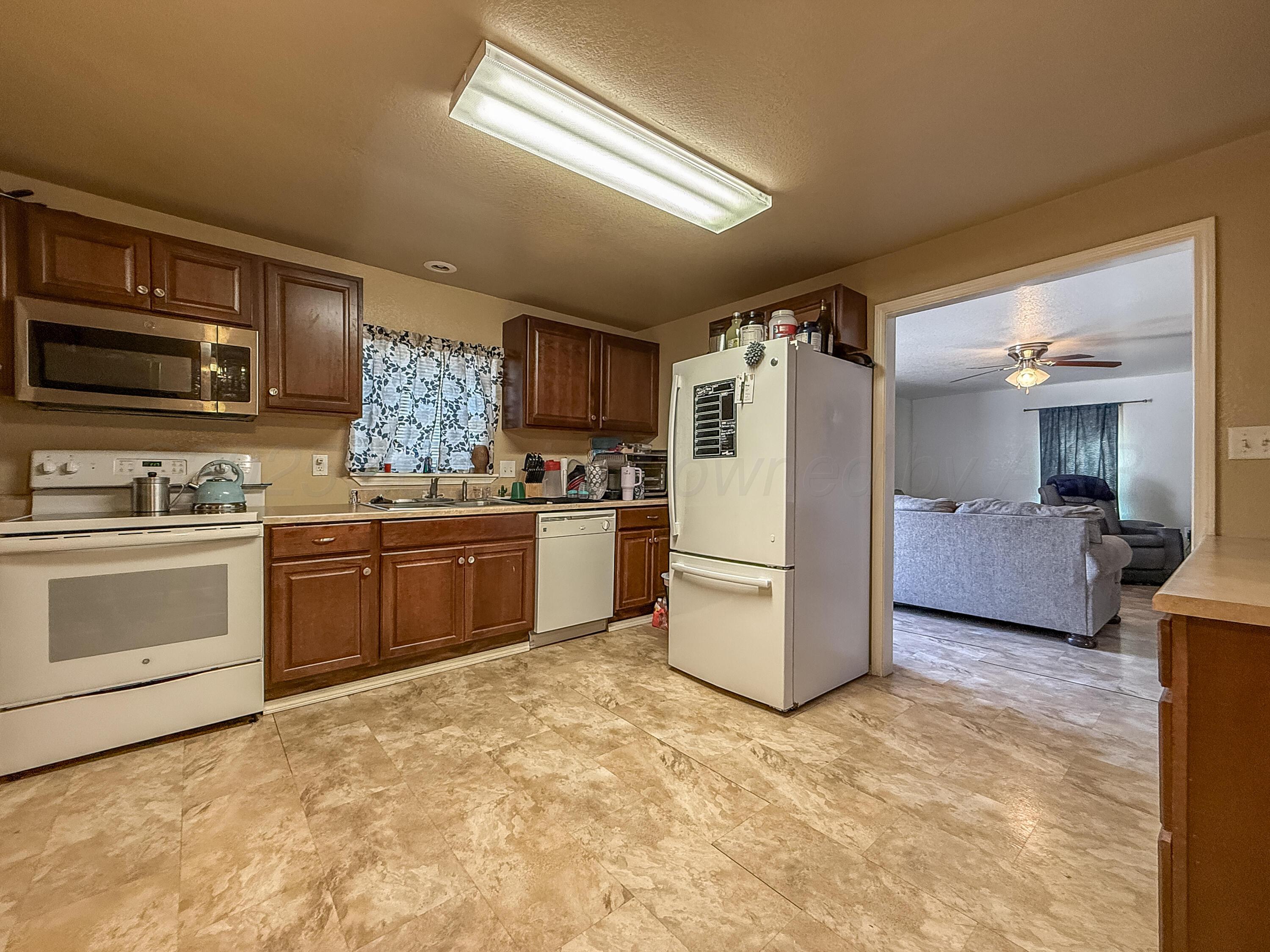 505 North Cedar Street Borger, TX 79007 - Photo 5 of 15 a kitchen with a refrigerator and a stove top oven