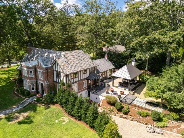 an aerial view of a house with swimming pool and lawn chairs under an umbrella