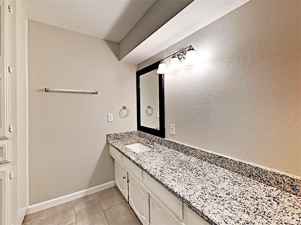 3413 Valley View Lane Garland, TX 75043 - Photo 9 of 12 a bathroom with a granite countertop sink and a mirror