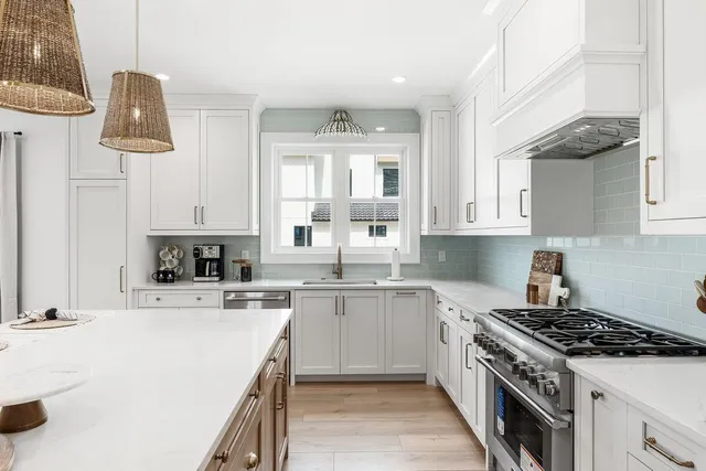 a kitchen with a stove a sink and living room view