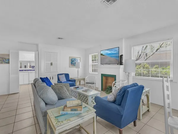 a living room with furniture a fireplace and a large window