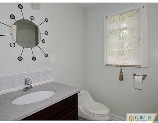 1881 Raritan Road Scotch Plains, NJ 07076 - Photo 10 of 18 a bathroom with a granite countertop sink a toilet and mirror