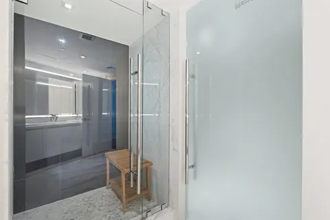 a bathroom with a glass shower door and a sink