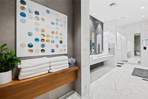 a bathroom with a granite countertop sink a toilet and shower