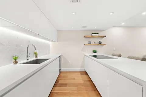 a view of a kitchen with a sink and wooden floor