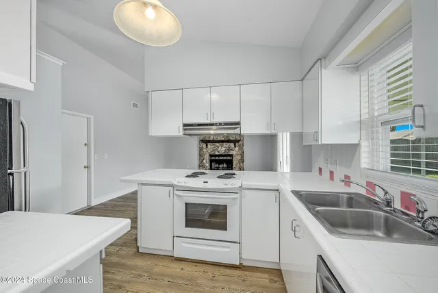 a kitchen with a stove sink and cabinets