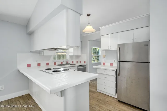 a kitchen with a white cabinets stove and refrigerator