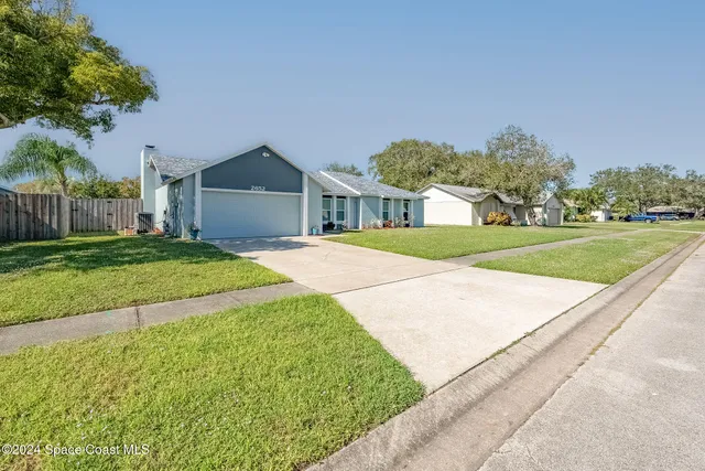 a front view of a house with a yard and trees