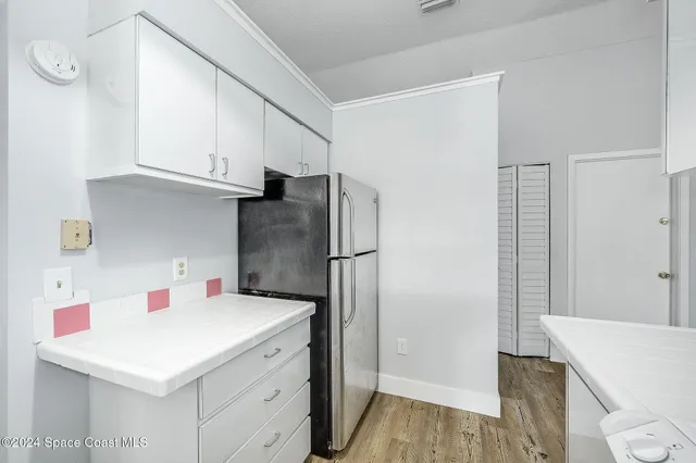 a kitchen with a sink a refrigerator and cabinets