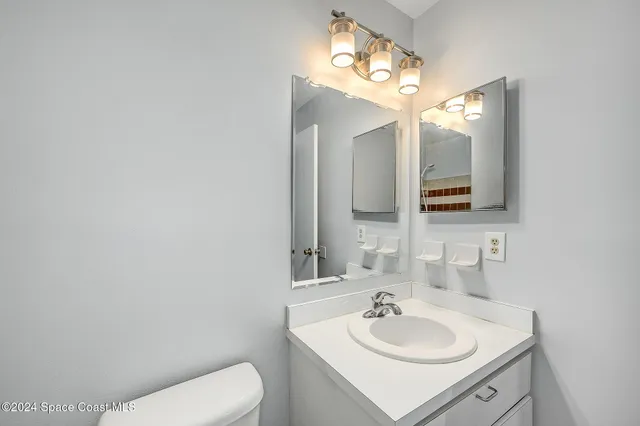 a bathroom with a toilet sink and mirror