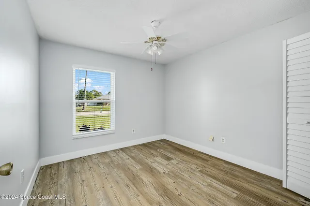 an empty room with a window and wooden floor