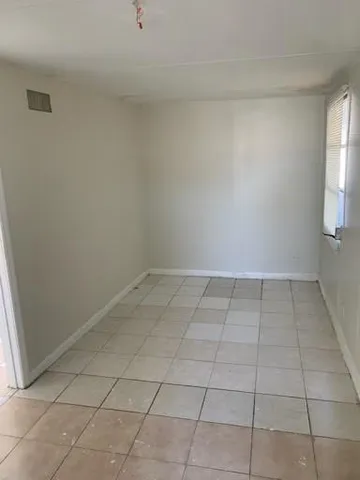 a view of a room with white tiles and a window