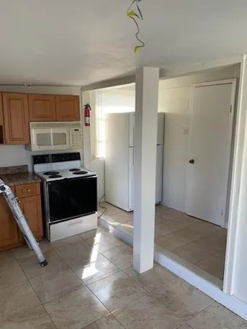 a view of kitchen with refrigerator stove and microwave