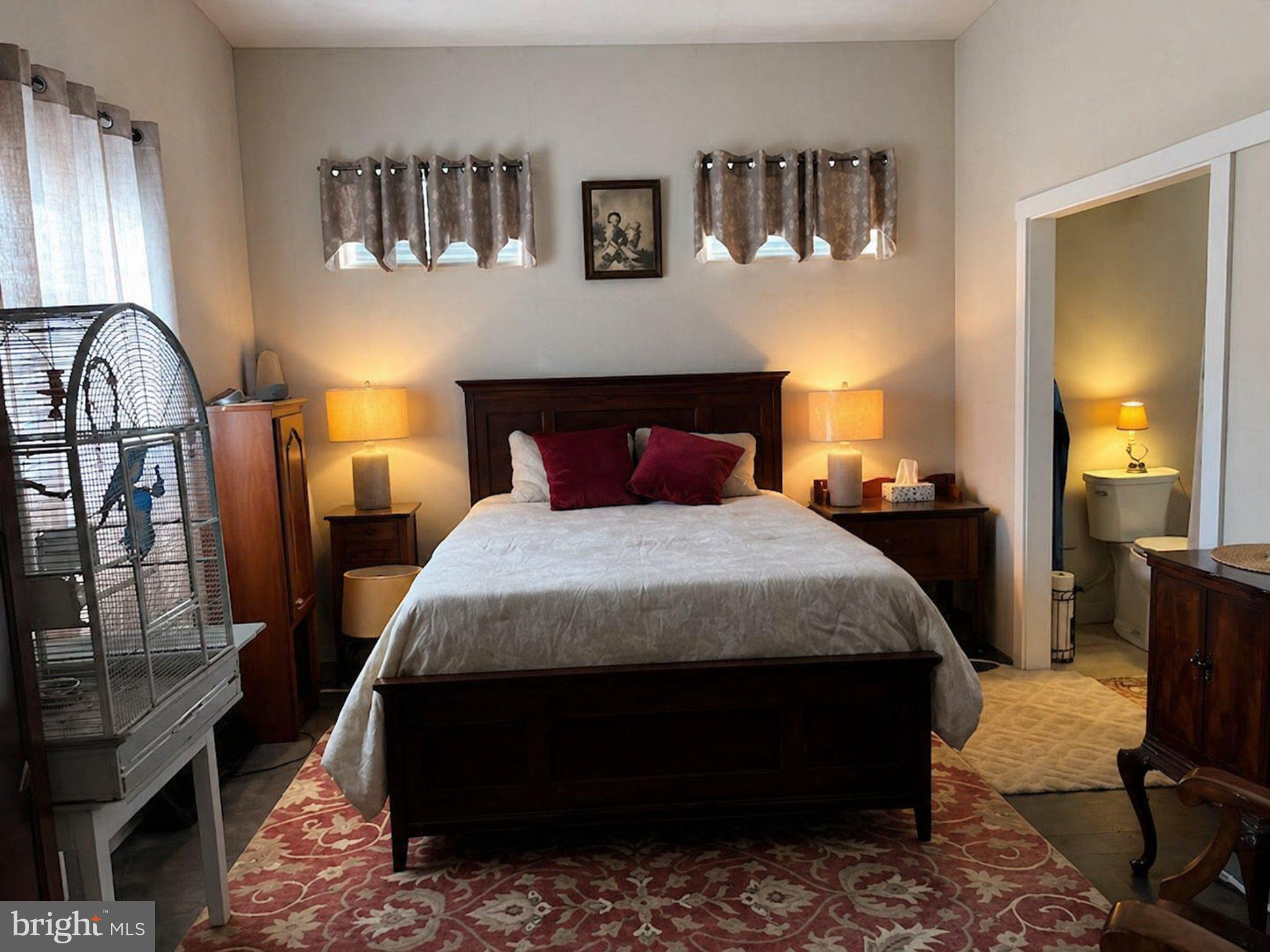867 Kibler Road Quicksburg, VA 22847 - Photo 11 of 18 a bedroom with a bed a mirror on the dresser and a window
