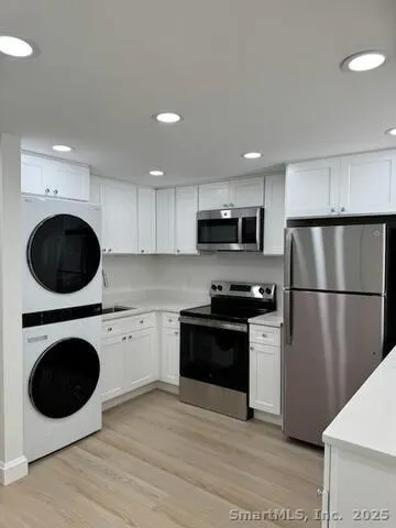 a kitchen with stainless steel appliances a refrigerator a stove top oven a sink and cabinets