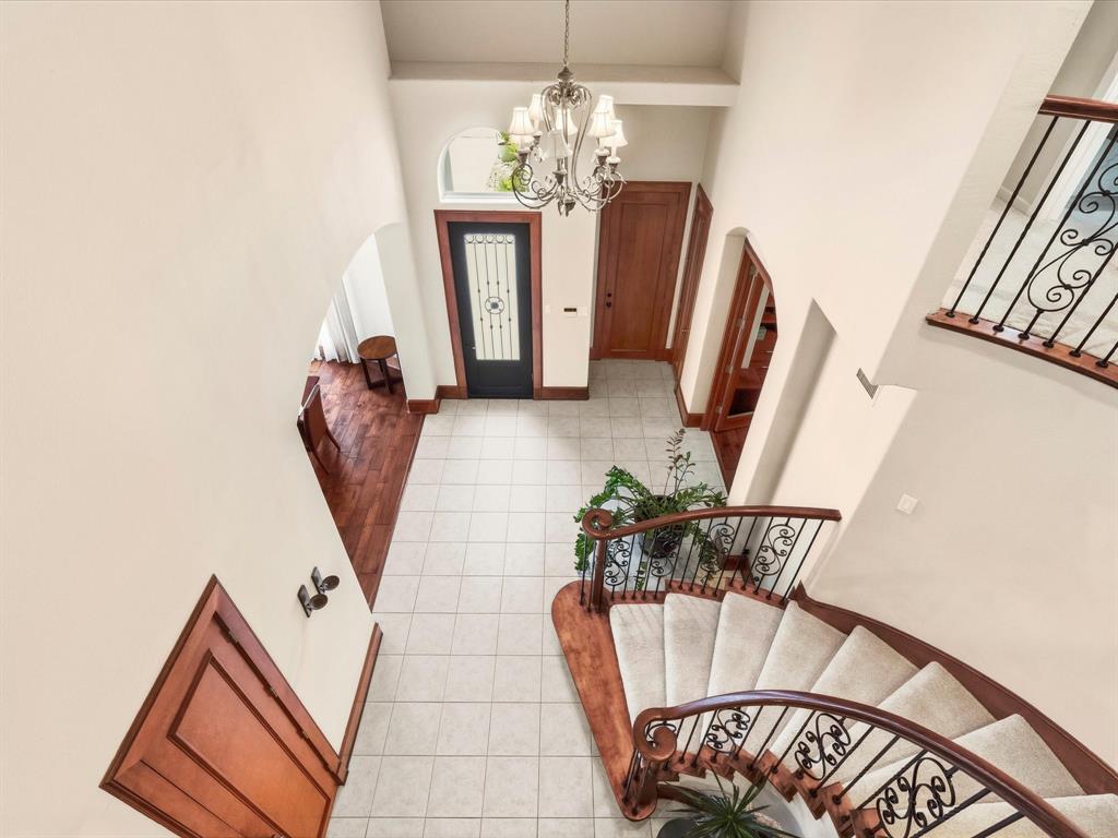 1615 Roma Lane Allen, TX 75013 - Photo 20 of 36 Grand entryway featuring a curved staircase with carpeted treads and ornate wrought iron balusters