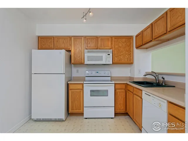 a kitchen with stainless steel appliances granite countertop a refrigerator a stove a sink and a microwave