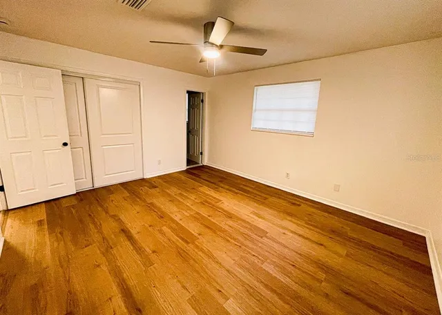 a view of empty room with wooden floor