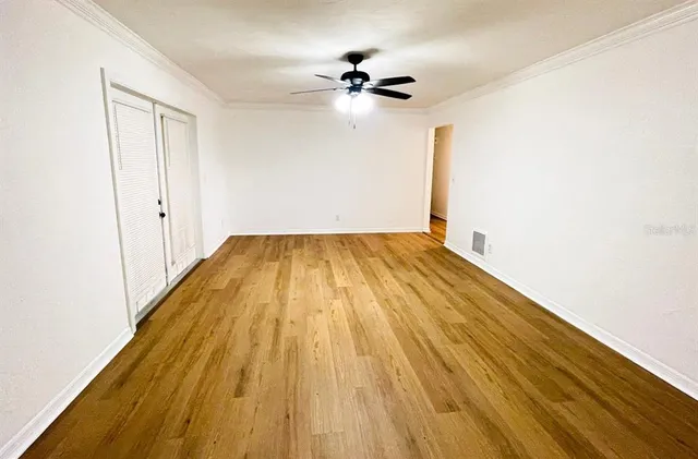 a view of empty room with wooden floor