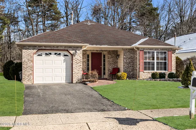 a view of a hallway view with wooden floor and a living room