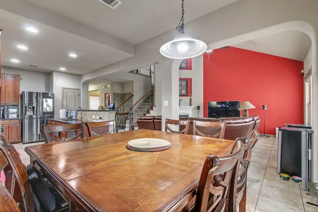 a kitchen with stainless steel appliances granite countertop a table chairs sink refrigerator and microwave