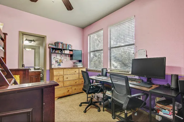 a view of a workspace with furniture and a window